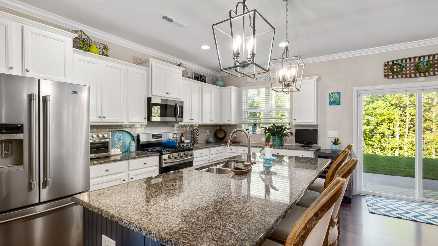 A kitchen with white cabinets and a large island