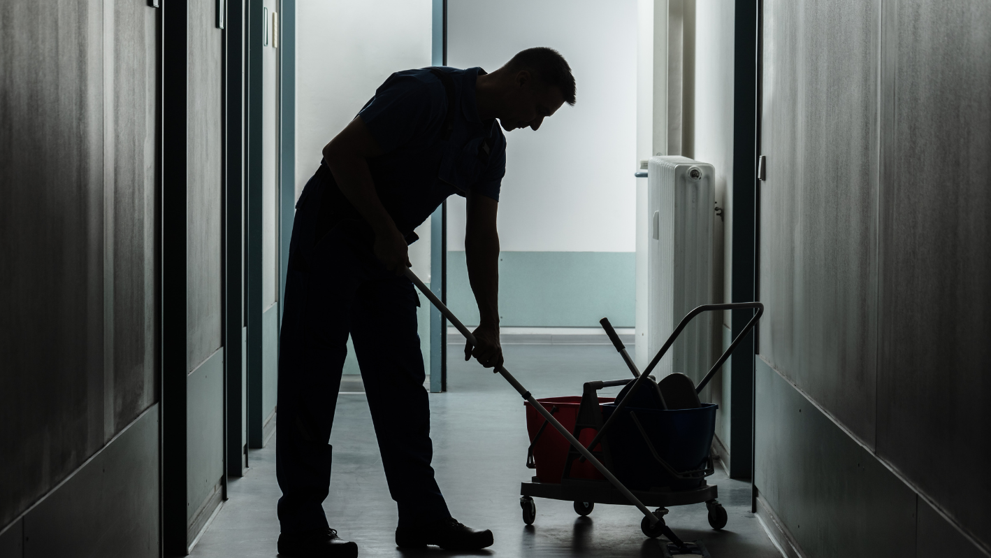 A man is cleaning the floor with a mop